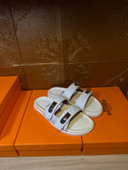 White Hermes slide sandals, two-strap design with silver buckles and open toe