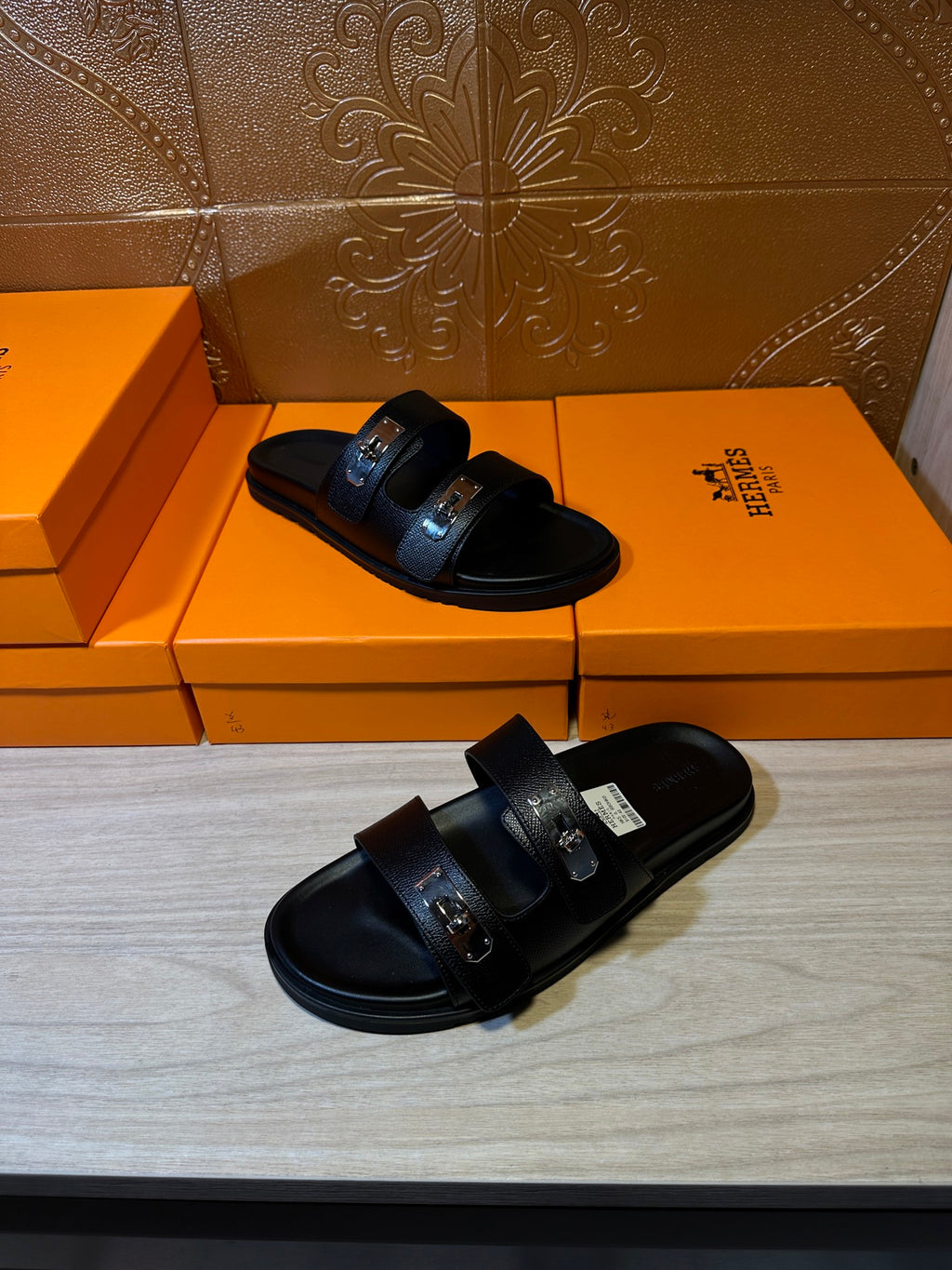 Hermes black leather sandals, front and side angles showing buckle hardware