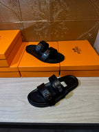Hermes black leather sandals, front and side angles showing buckle hardware