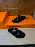 Hermes black leather slide sandals with two adjustable straps and metal buckles