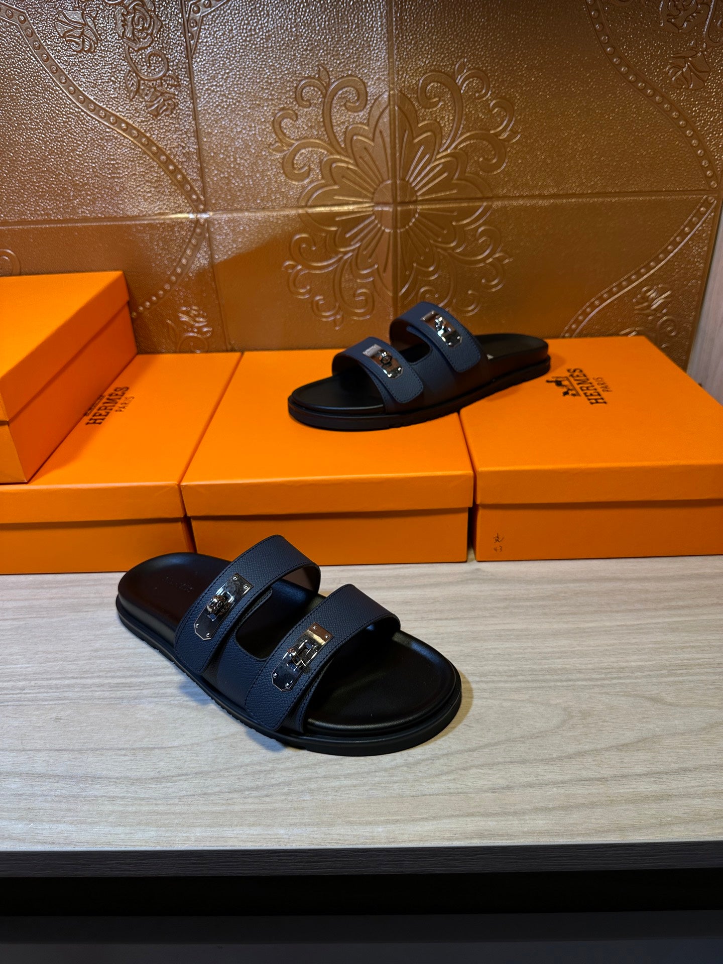 Pair of Hermes blue slide sandals with black footbeds and silver buckle accents