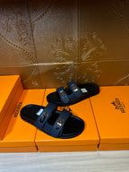 Hermes blue leather slide sandals, close side view with two metal buckles