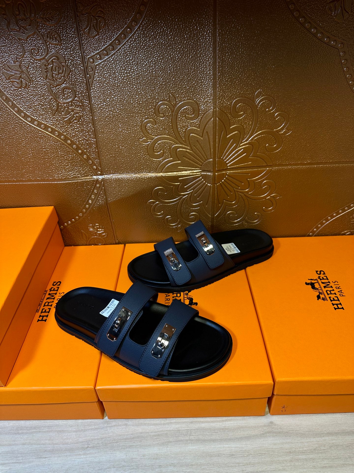 Hermes blue leather slide sandals, close side view with two metal buckles