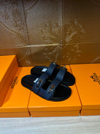 Hermes blue slide sandals with black footbed and silver-tone buckle details