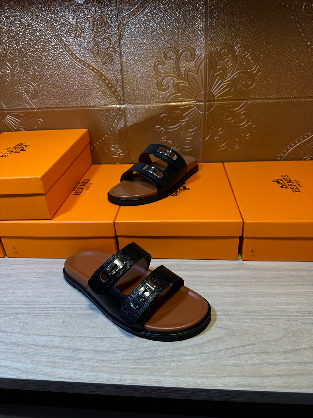 Dark slide sandals on display; double strap and metal buckle hardware
