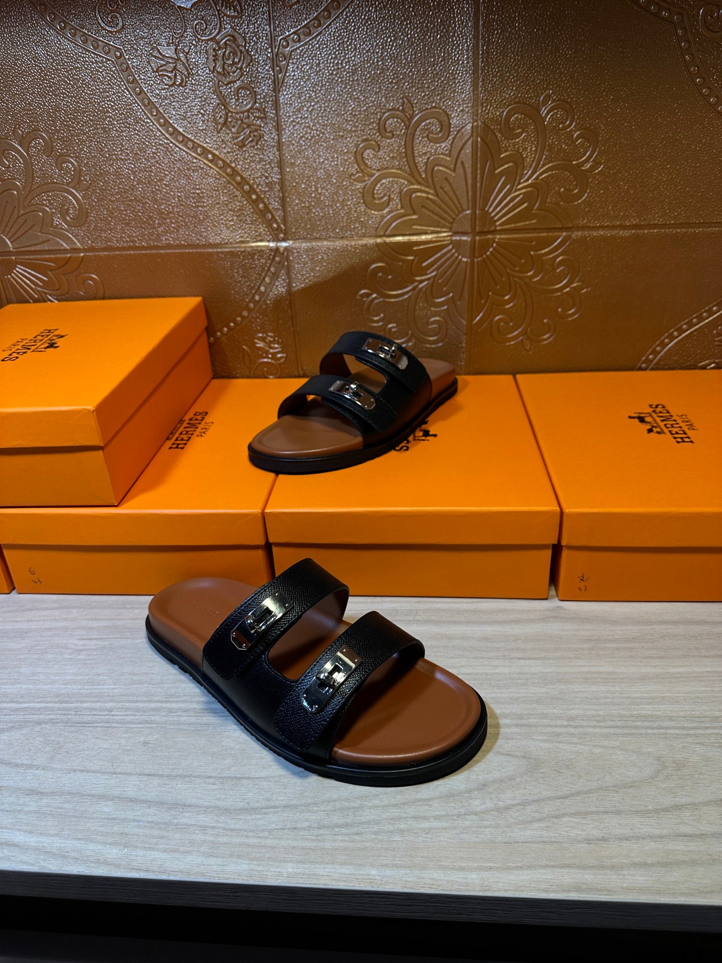 Dark slide sandals on display; double strap and metal buckle hardware