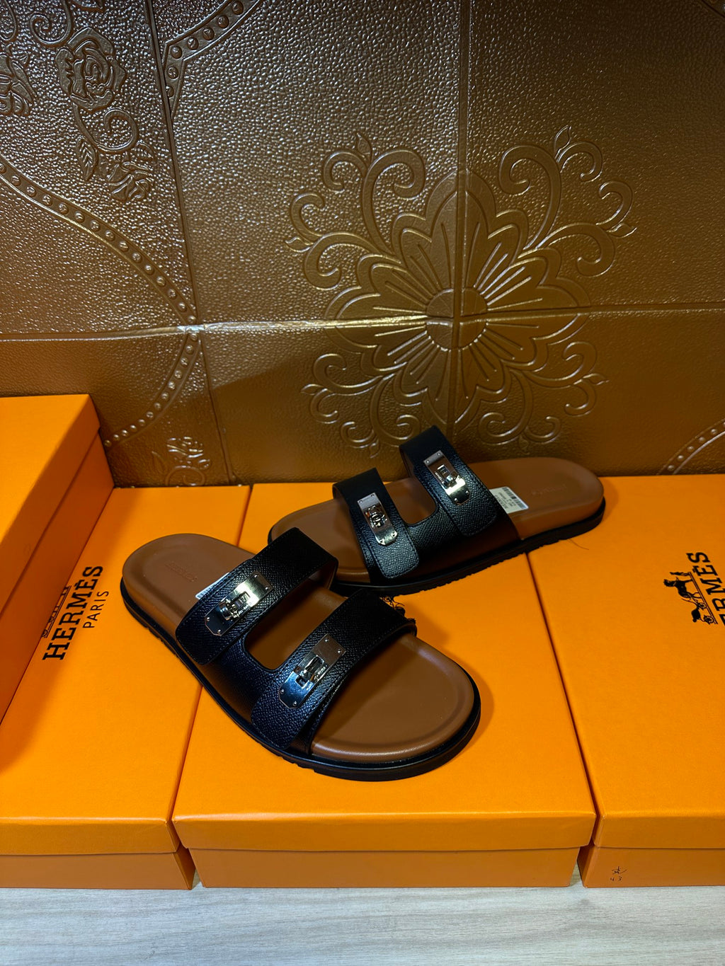 Dark two-strap sandals with metal buckle accents on the vamp