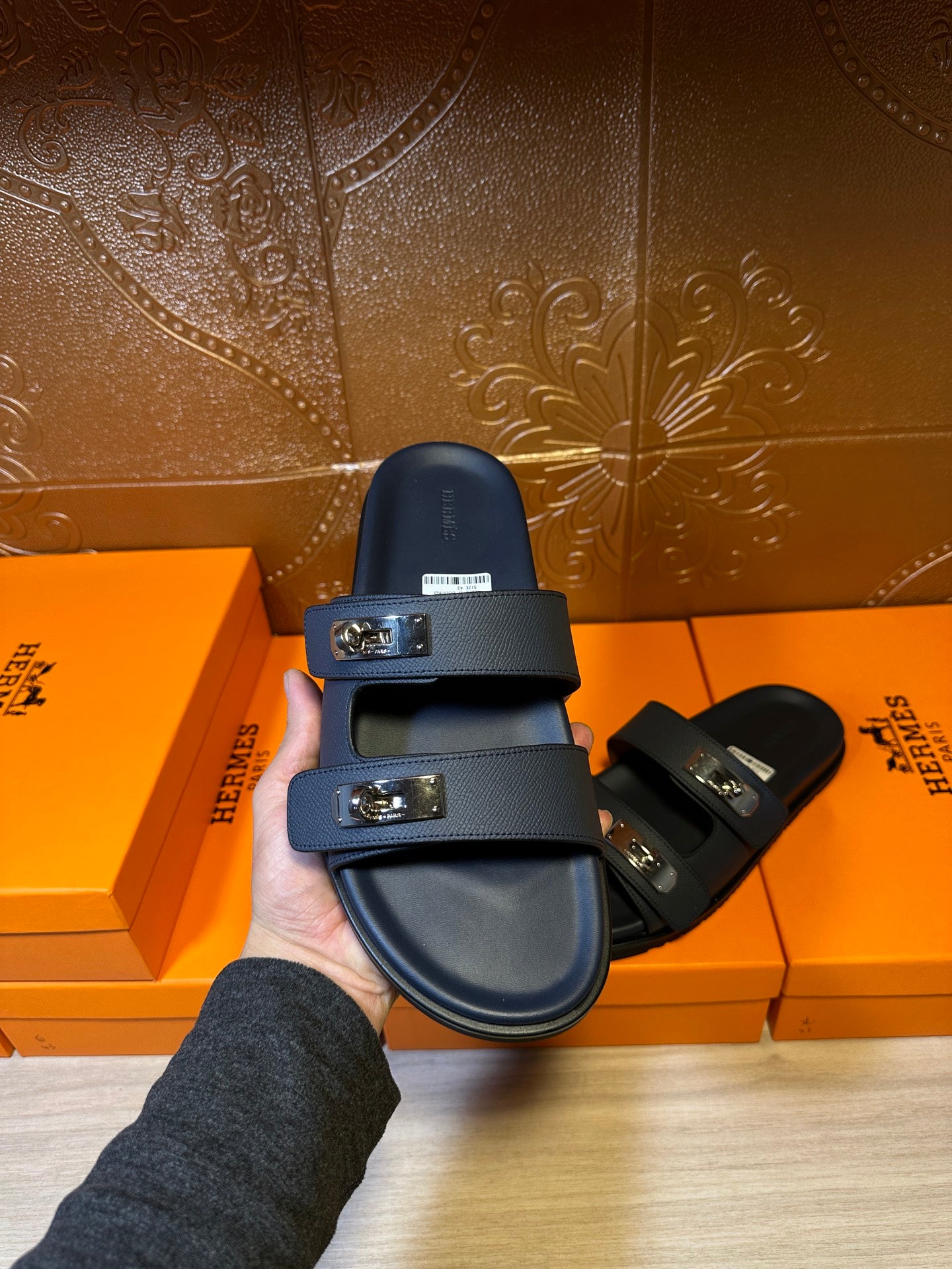 Blue leather slide sandals with two buckle straps held for a front view