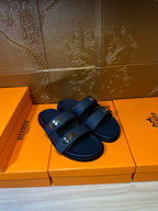 Blue two-strap leather slide sandals with metal buckles, pair shown on box