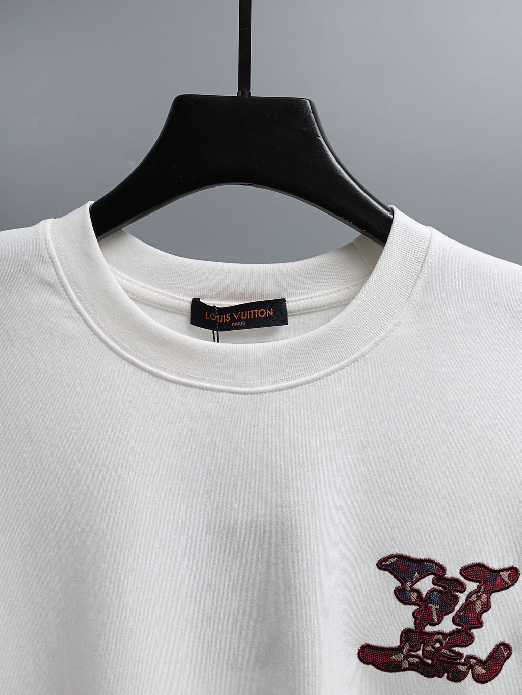 White T-shirt neckline with inner brand label and burgundy embroidered chest motif