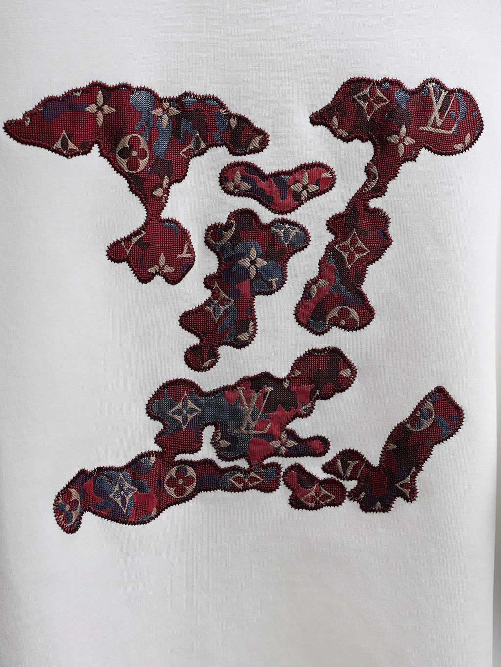 White T-shirt with large burgundy embroidered logo graphic across the front