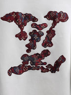 White T-shirt with large burgundy embroidered logo graphic across the front