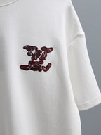 White T-shirt with burgundy embroidered logo motif on the sleeve-side chest