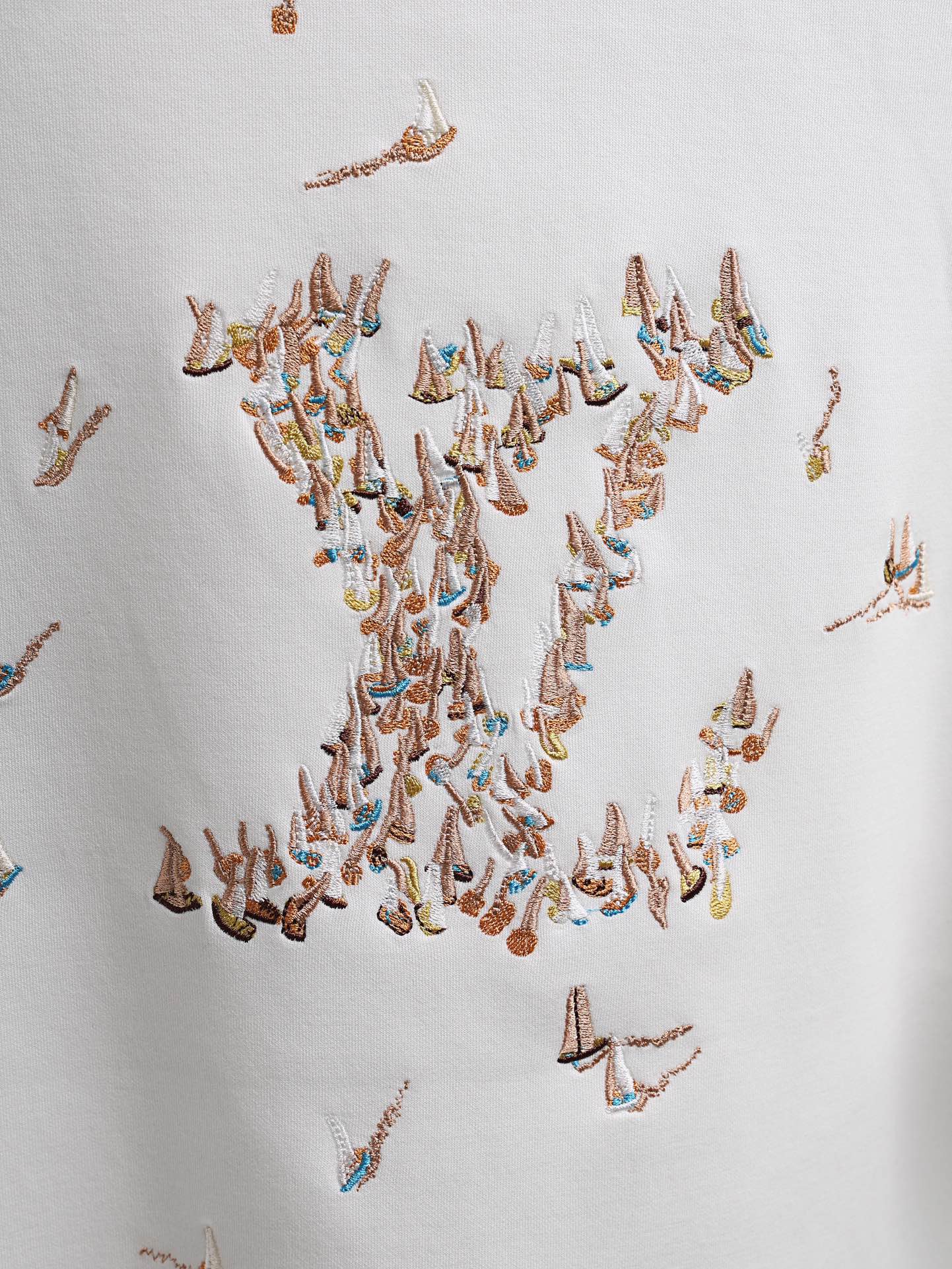 White T-shirt with dense multicolor embroidered bird pattern across the chest