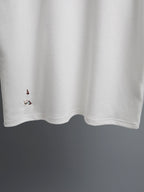White T-shirt with embroidered bird details along the lower front hem