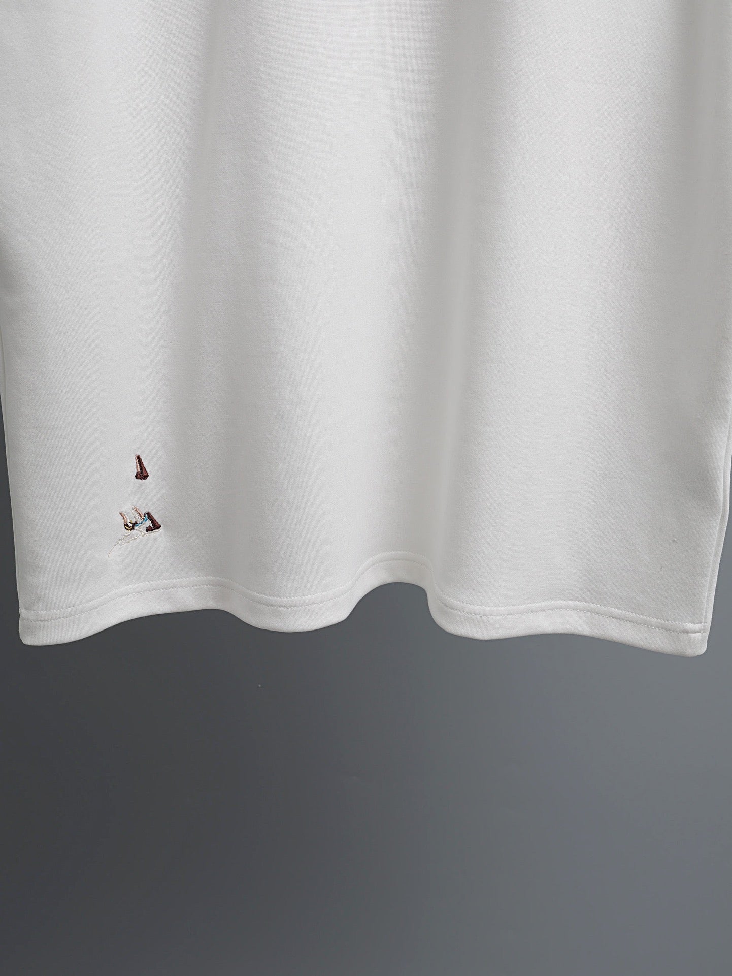 White T-shirt with embroidered bird details along the lower front hem