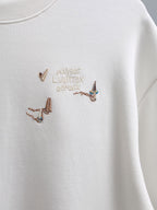 White crewneck T-shirt with multicolor embroidered bird motif at the center chest