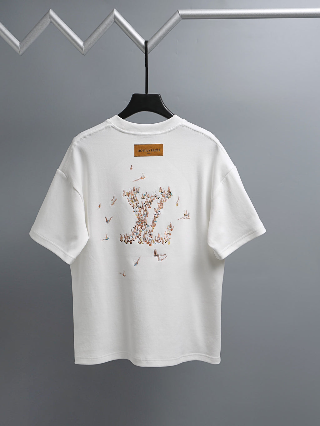 White T-shirt with graphic dot pattern on back and small logo label
