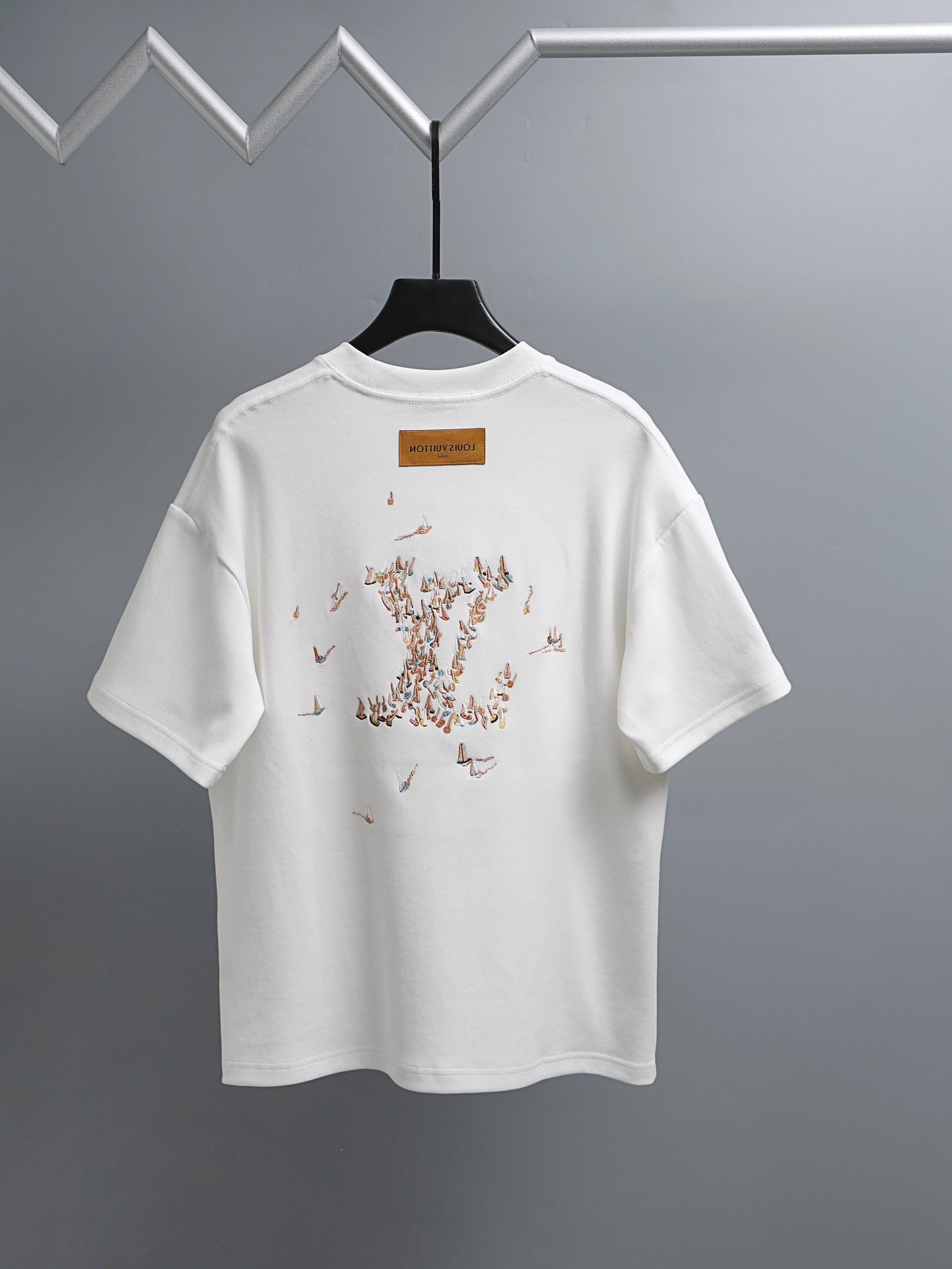 White T-shirt with graphic dot pattern on back and small logo label