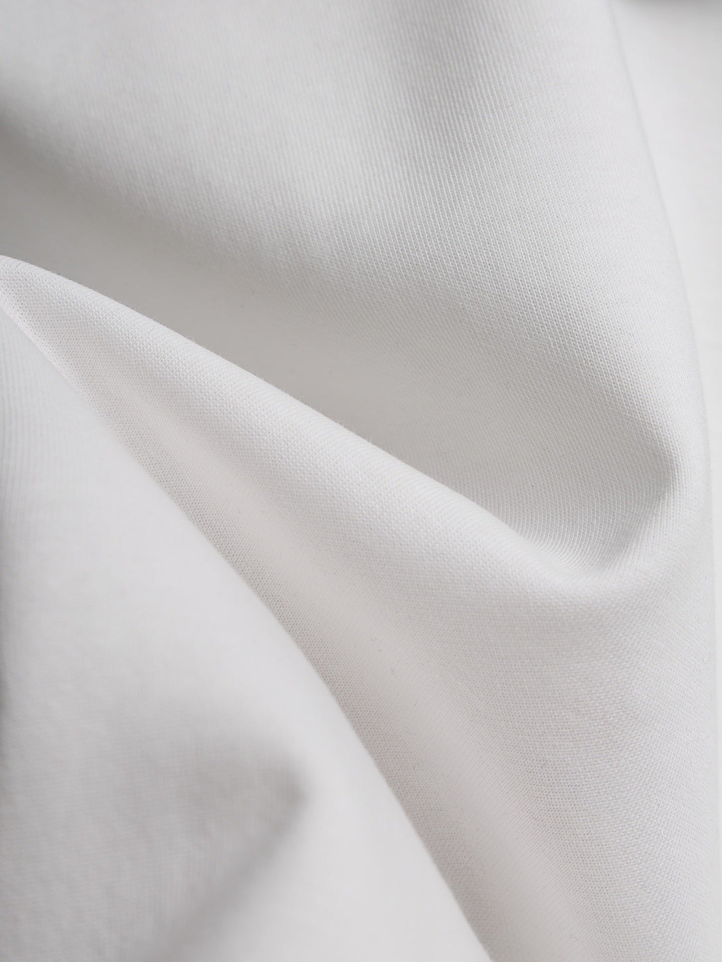 White T-shirt fabric close-up with soft drape and visible knit texture