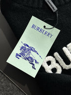 Black knit sweater with green BURBERRY hangtag and blue horse emblem
