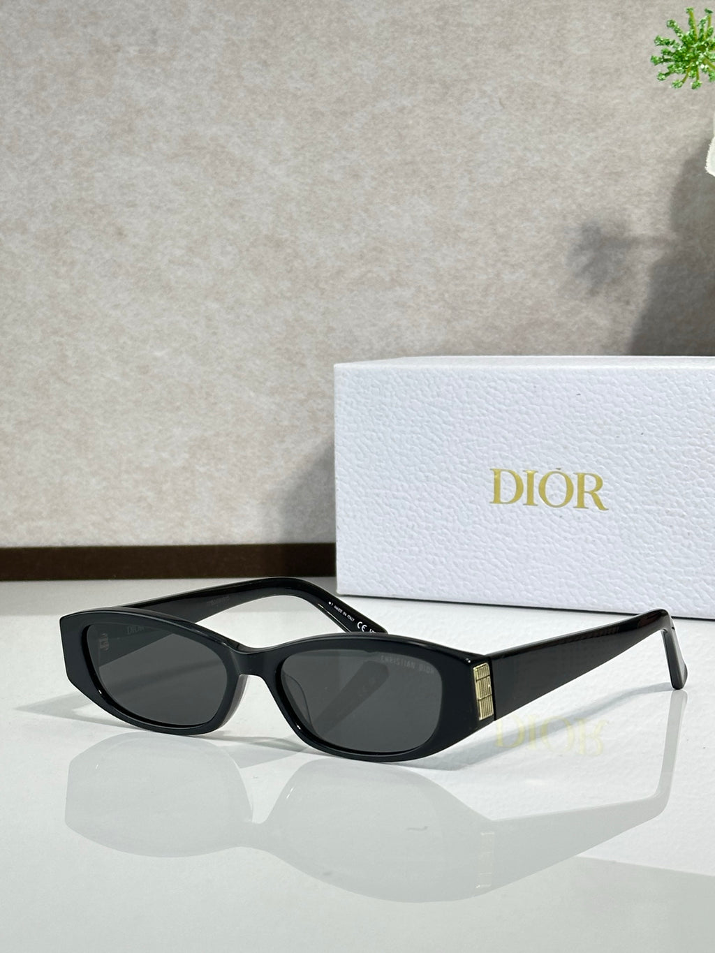 Black cat-eye sunglasses with dark lenses and gold temple accent
