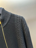 Dark knit zip-up sweater sleeve and side zipper detail
