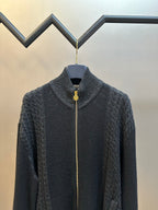 Dark knit zip-up sweater with mock neck and gold zipper pull