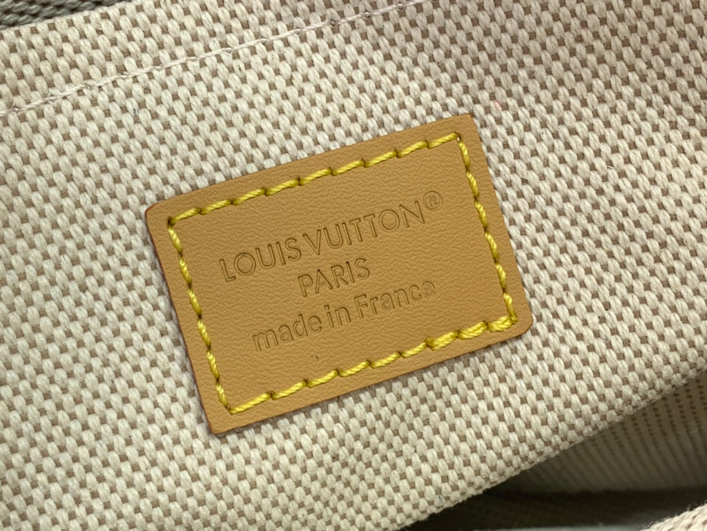 Louis Vuitton canvas interior label with yellow stitching and embossed logo