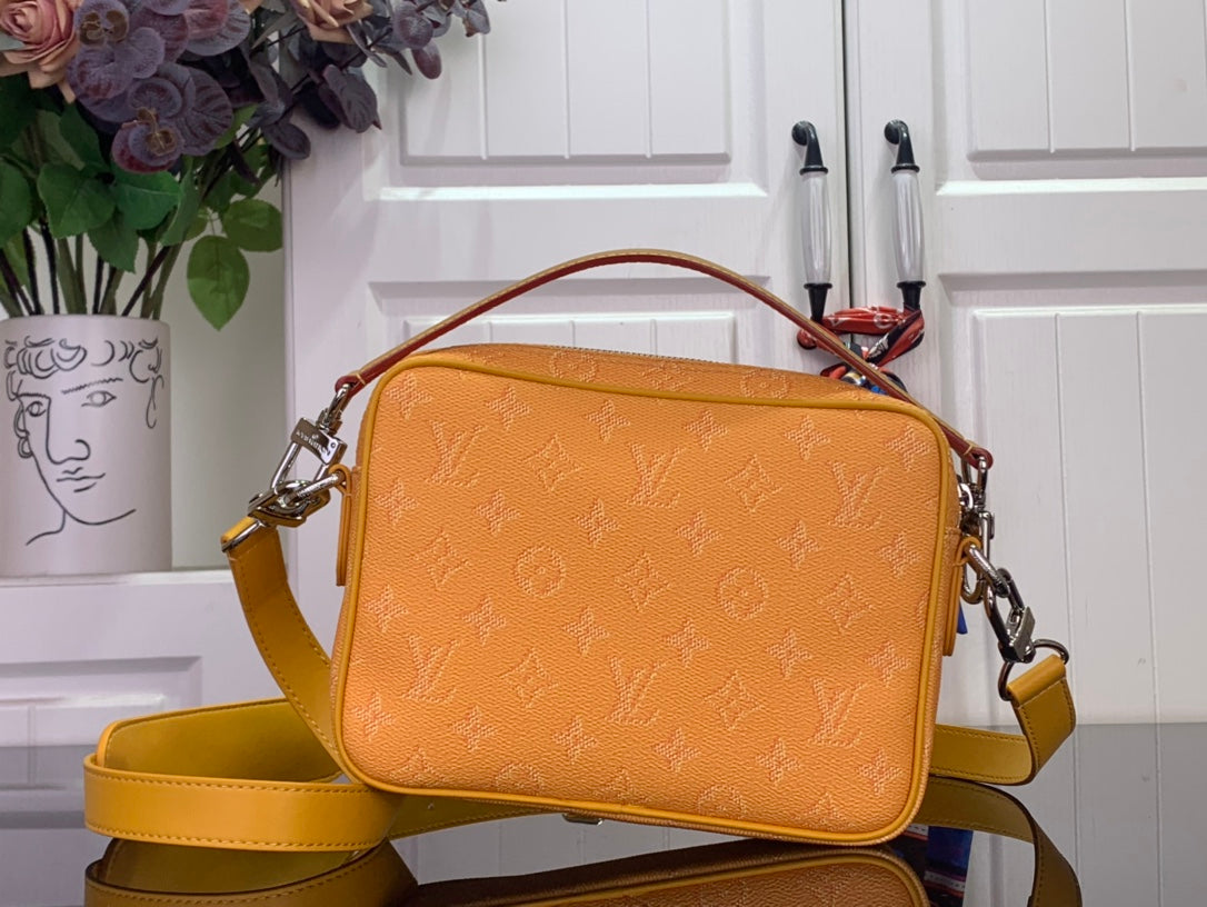 Orange monogram crossbody bag with short top handle and adjustable shoulder strap