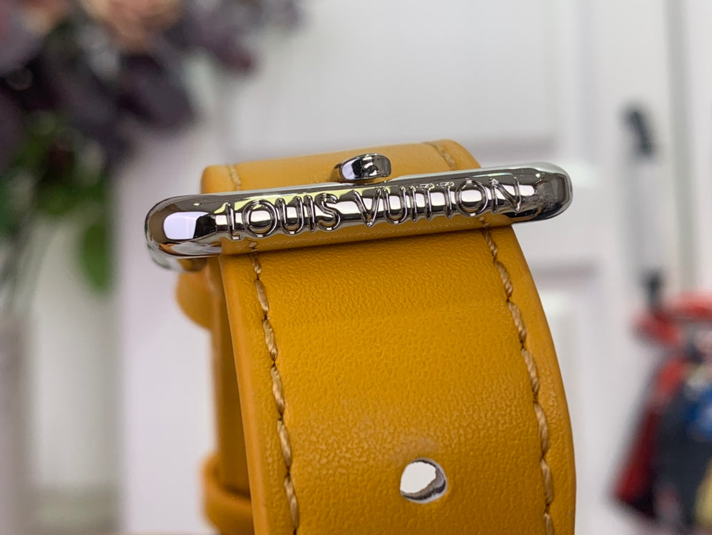 Gold-tone snap strap end with engraved Louis Vuitton logo on orange bag