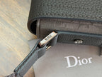 Dior bag side hardware and stitched strap end with metal clasp at the edge