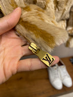Gold zipper pull on hooded fur jacket with Louis Vuitton logo hardware
