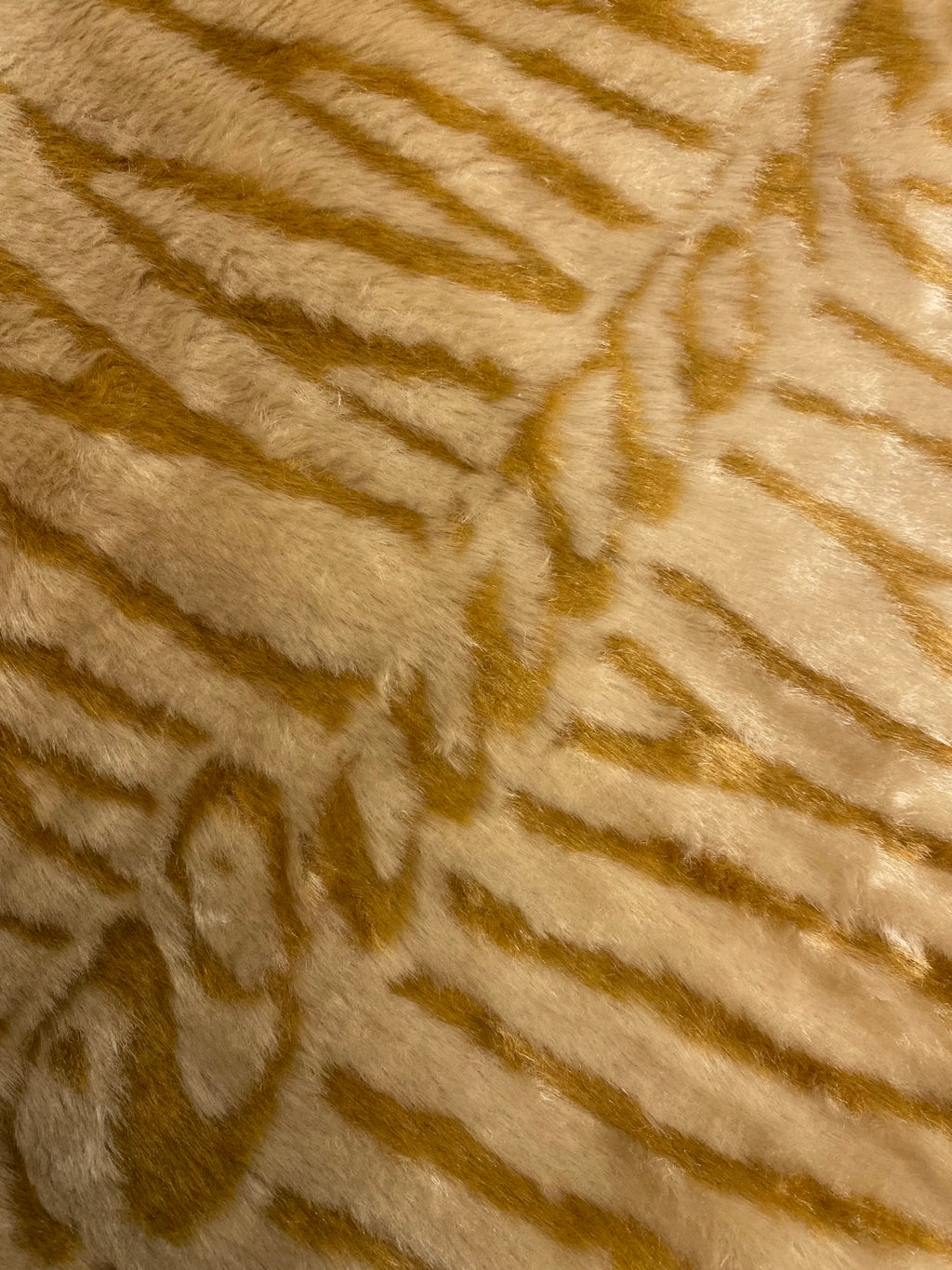 Close-up of gold-and-cream striped faux fur texture