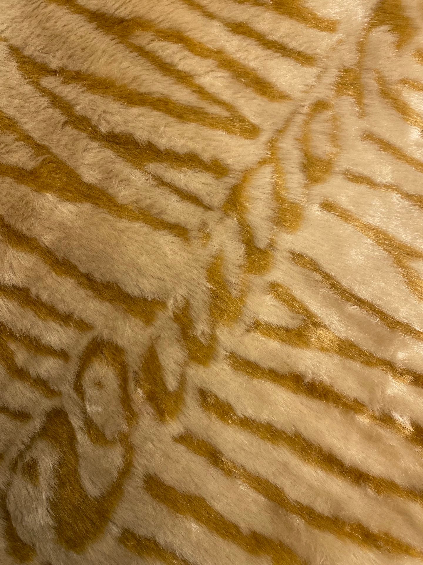 Close-up of gold-and-cream striped faux fur texture