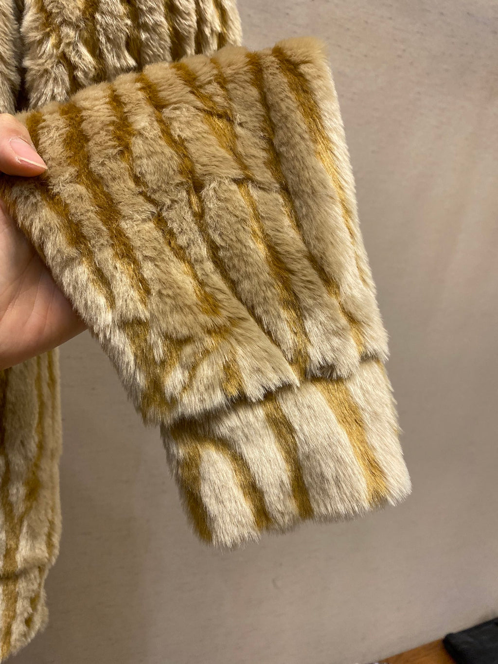 Ribbed cuff and hem of gold-and-cream striped fur jacket
