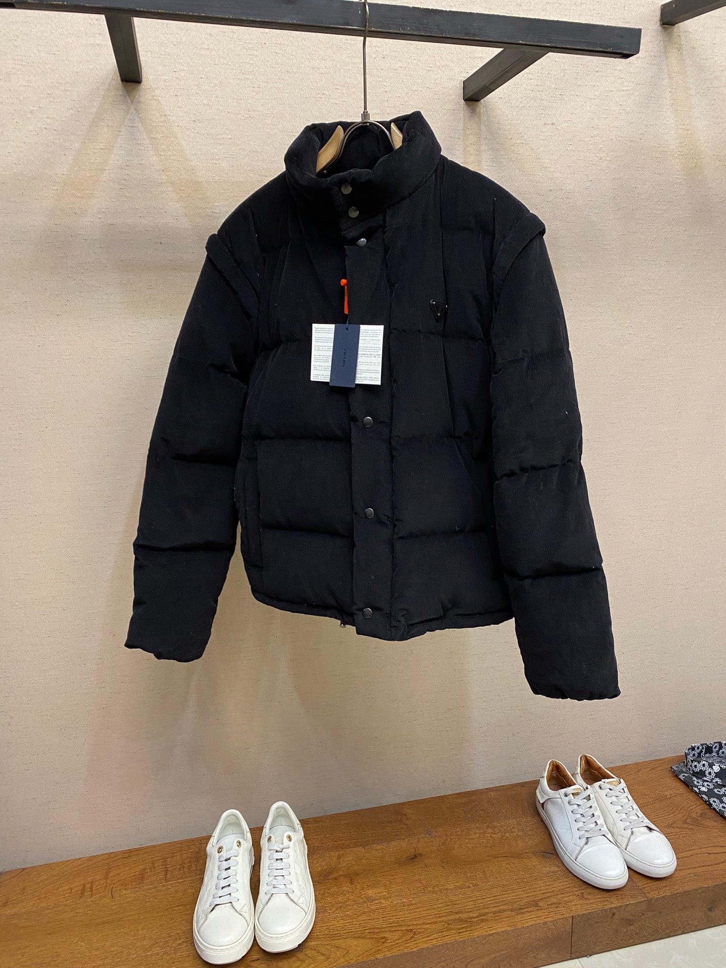 Black puffer jacket with hood, button front and two chest labels