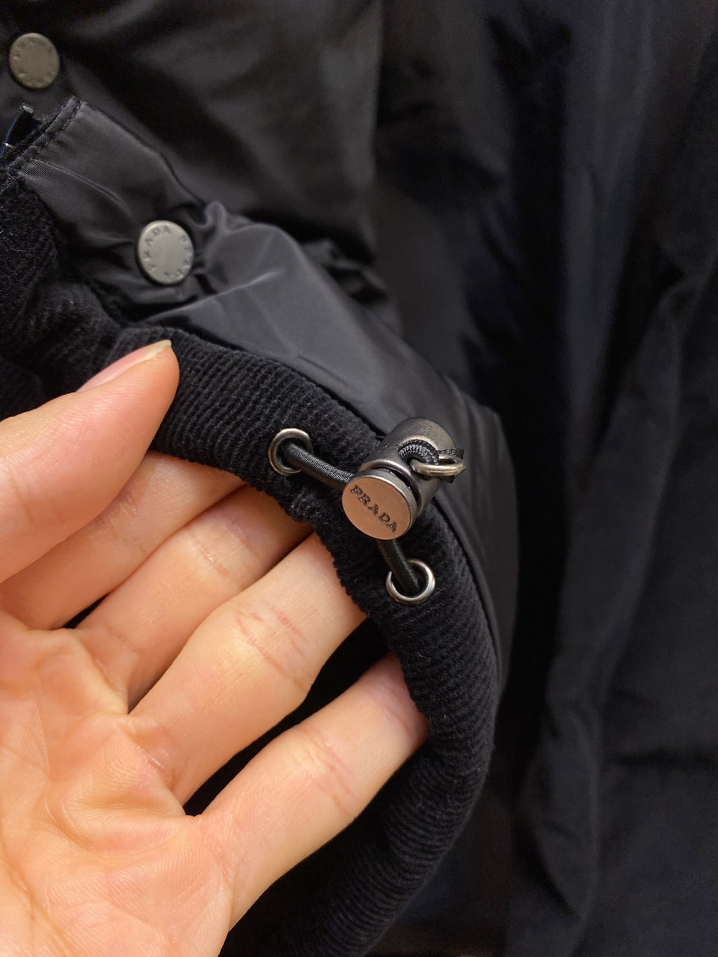 Black puffer jacket cuff with Prada logo eyelet cords