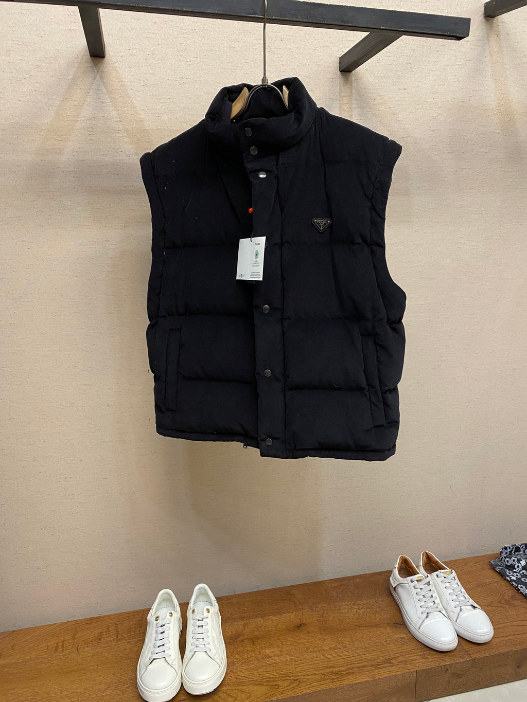 Black hooded puffer vest, snap front, quilted panels and hanging tag