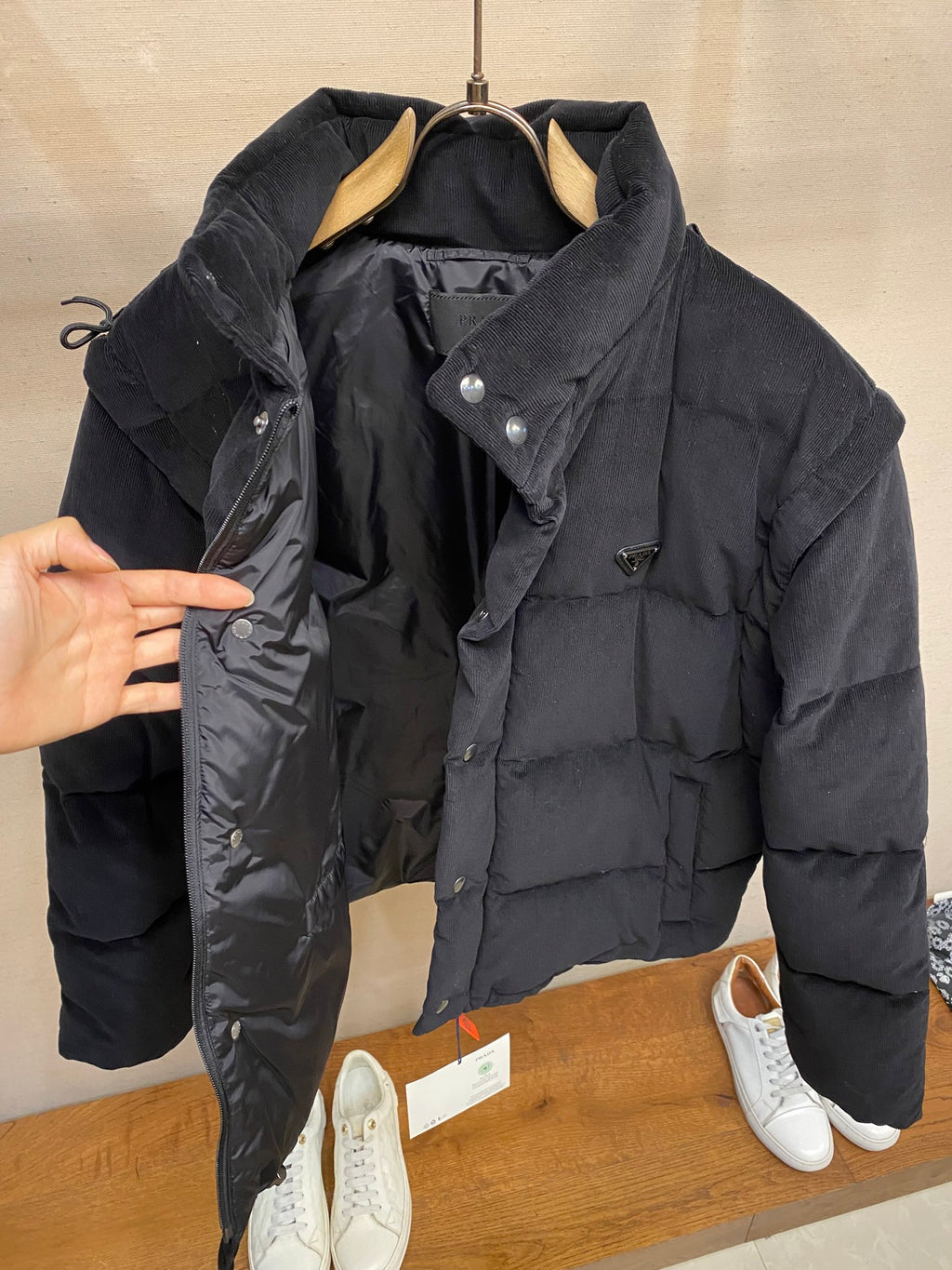 Black hooded puffer jacket with snap front, side zipper and inner tags