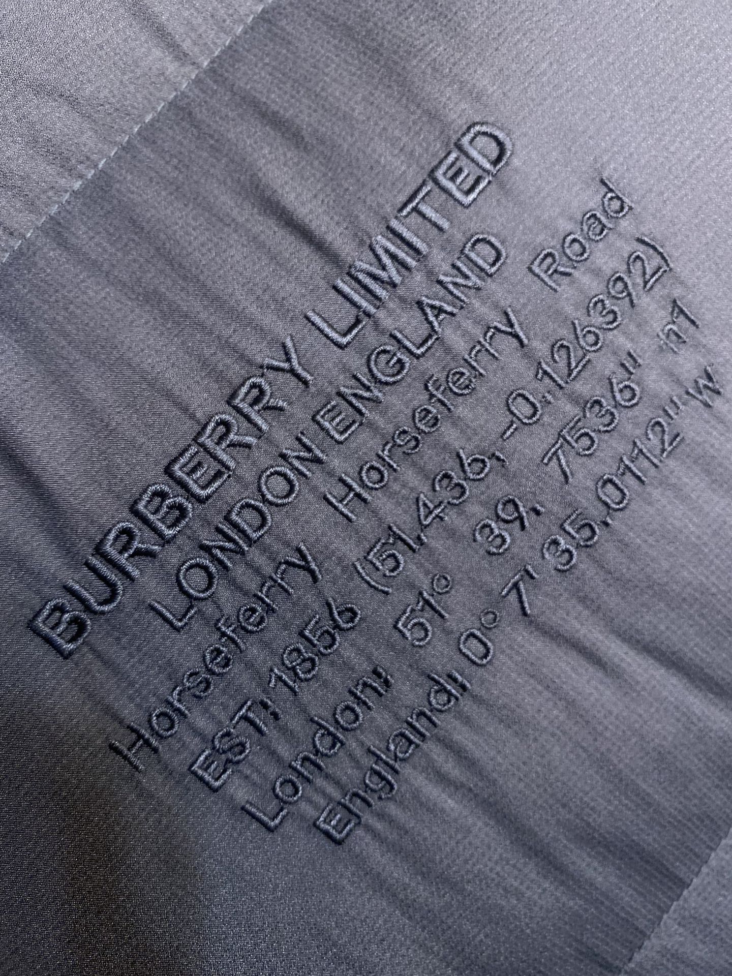 Dark gray fabric label text with LIMITED logo and care details