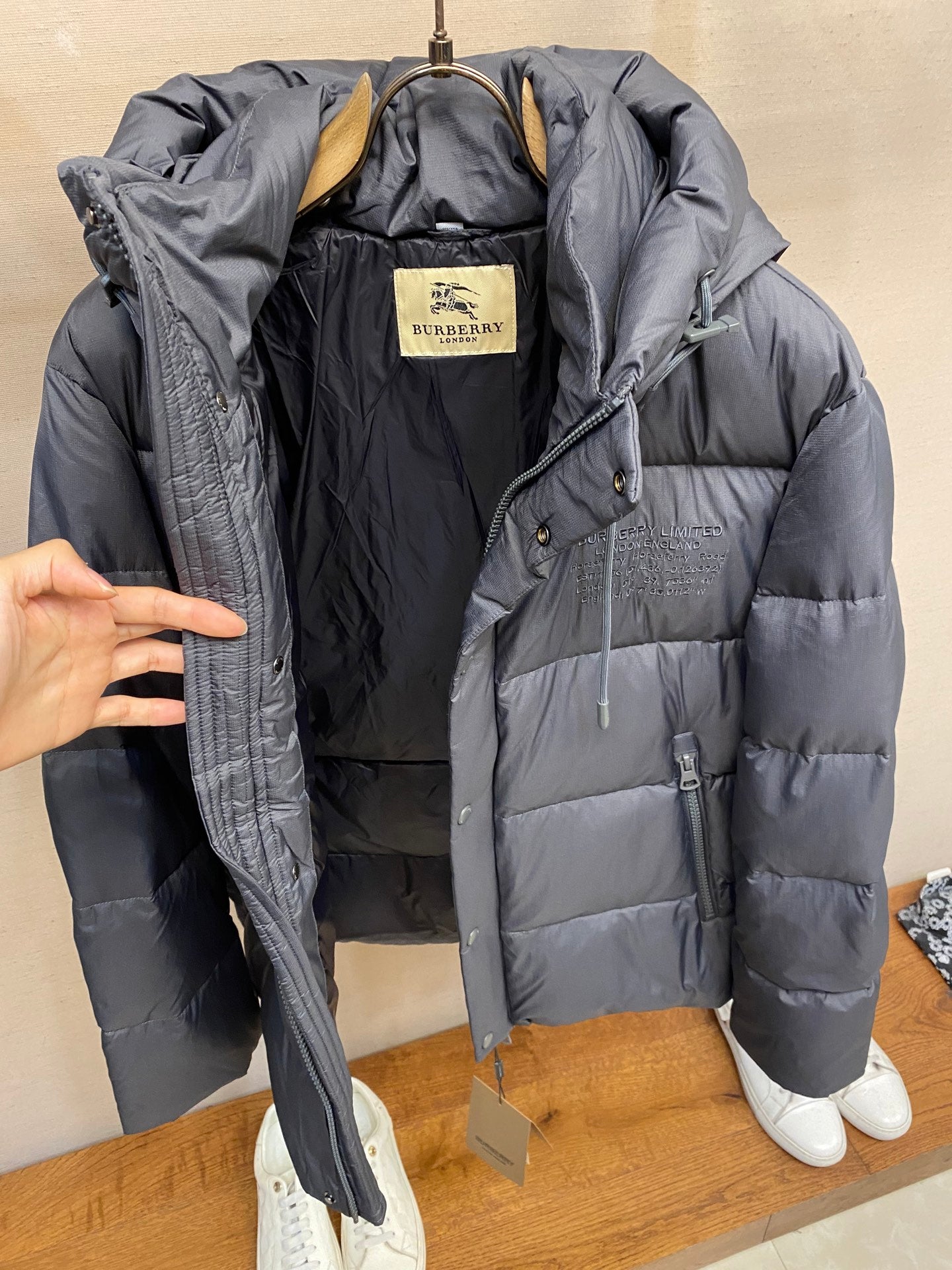 Open dark gray long puffer jacket showing inner Burberry label and pockets