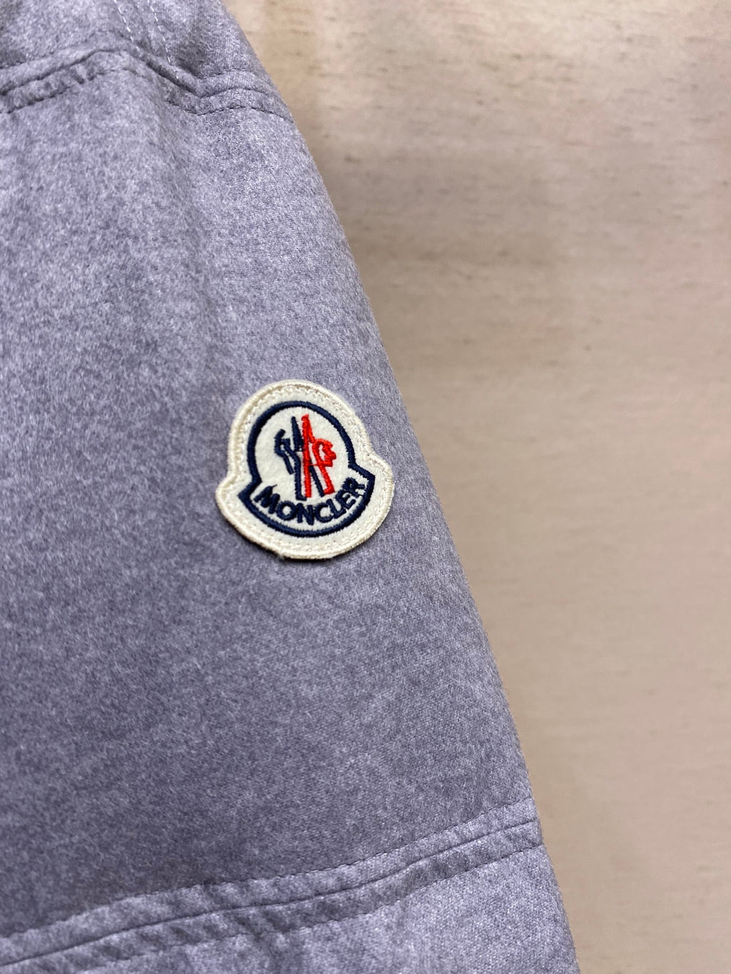 Moncler patch logo on light gray puffer jacket sleeve