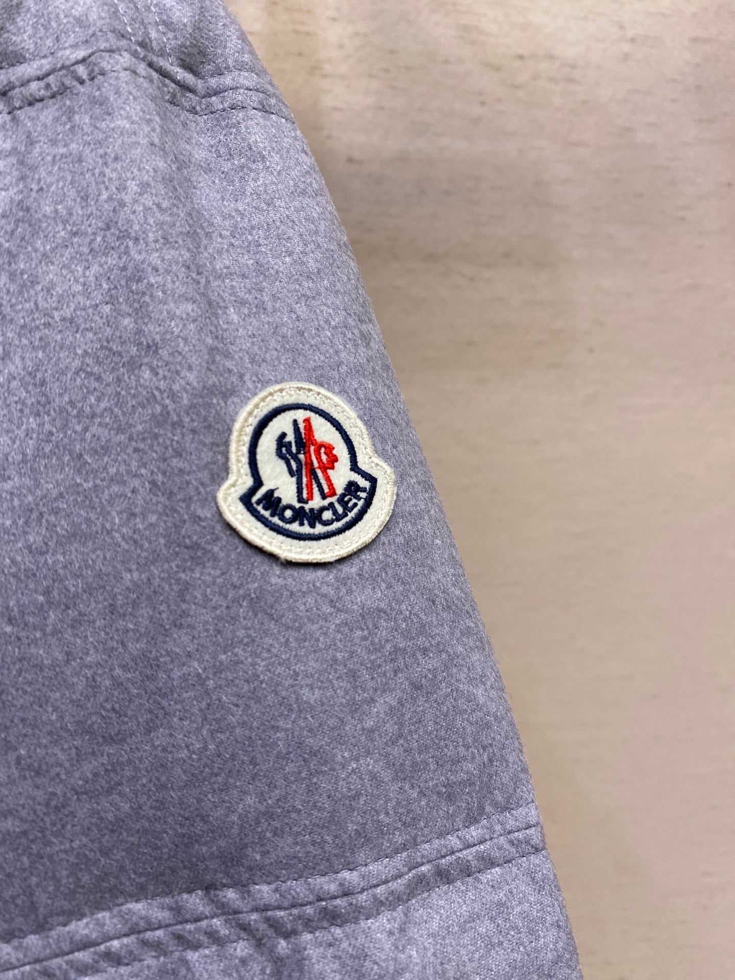 Moncler patch logo on light gray puffer jacket sleeve
