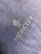 Moncler logo embroidery on light gray puffer jacket fabric