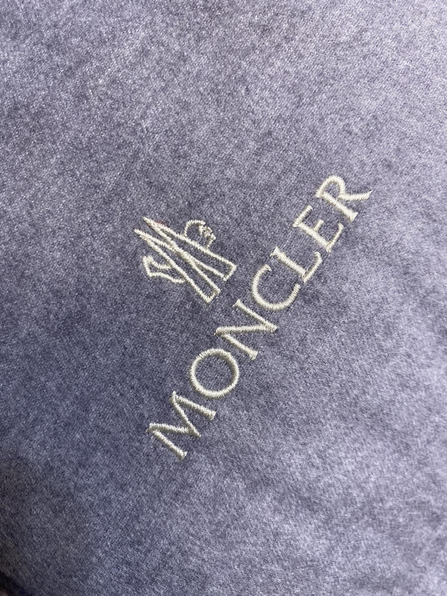 Moncler logo embroidery on light gray puffer jacket fabric