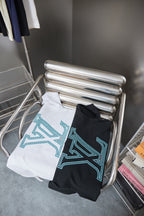Louis Vuitton T-shirt stack on rack: white and dark navy with light blue LV logos