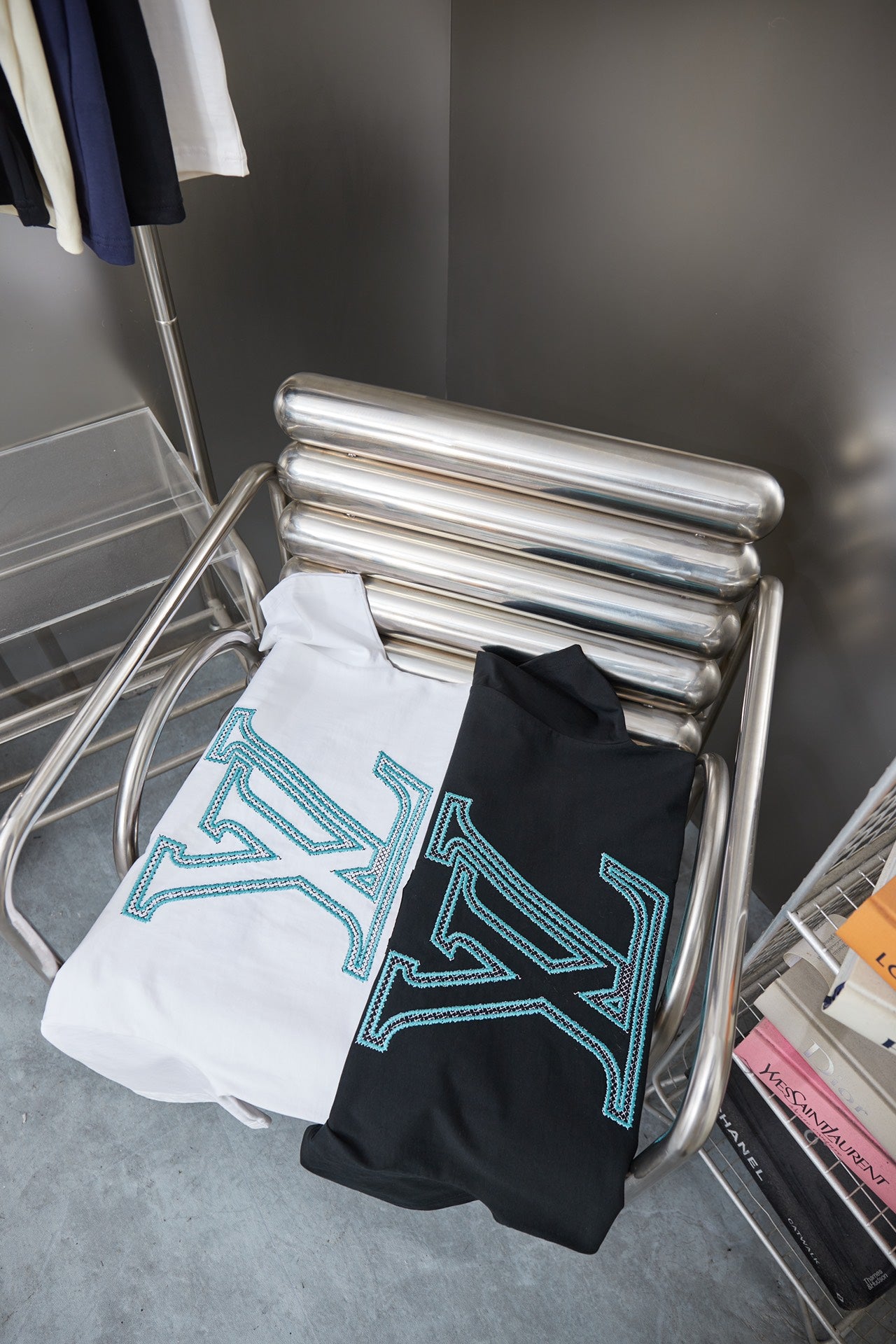 Louis Vuitton T-shirt stack on rack: white and dark navy with light blue LV logos