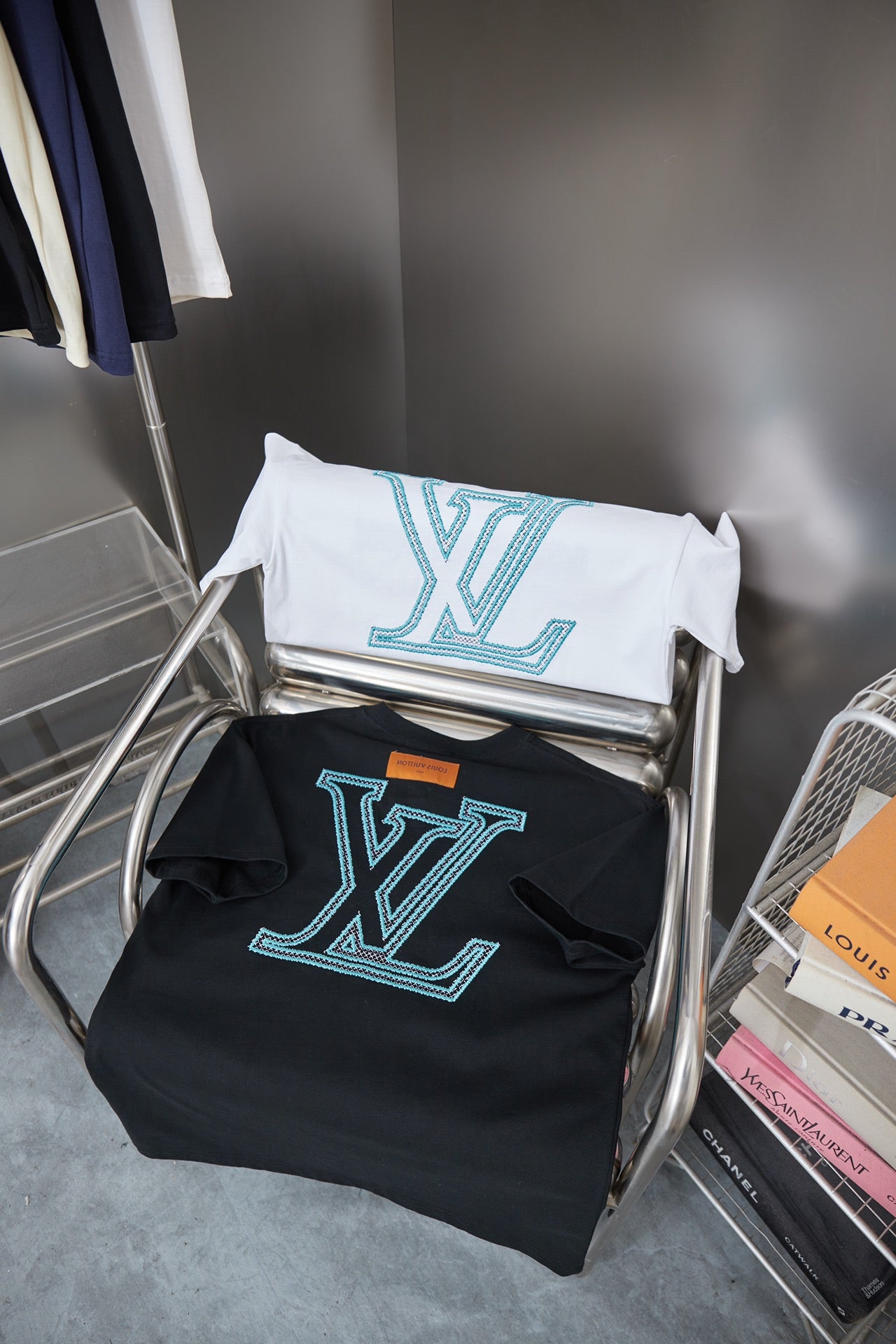 Louis Vuitton T-shirt stack on rack: white and dark navy with light blue LV logos