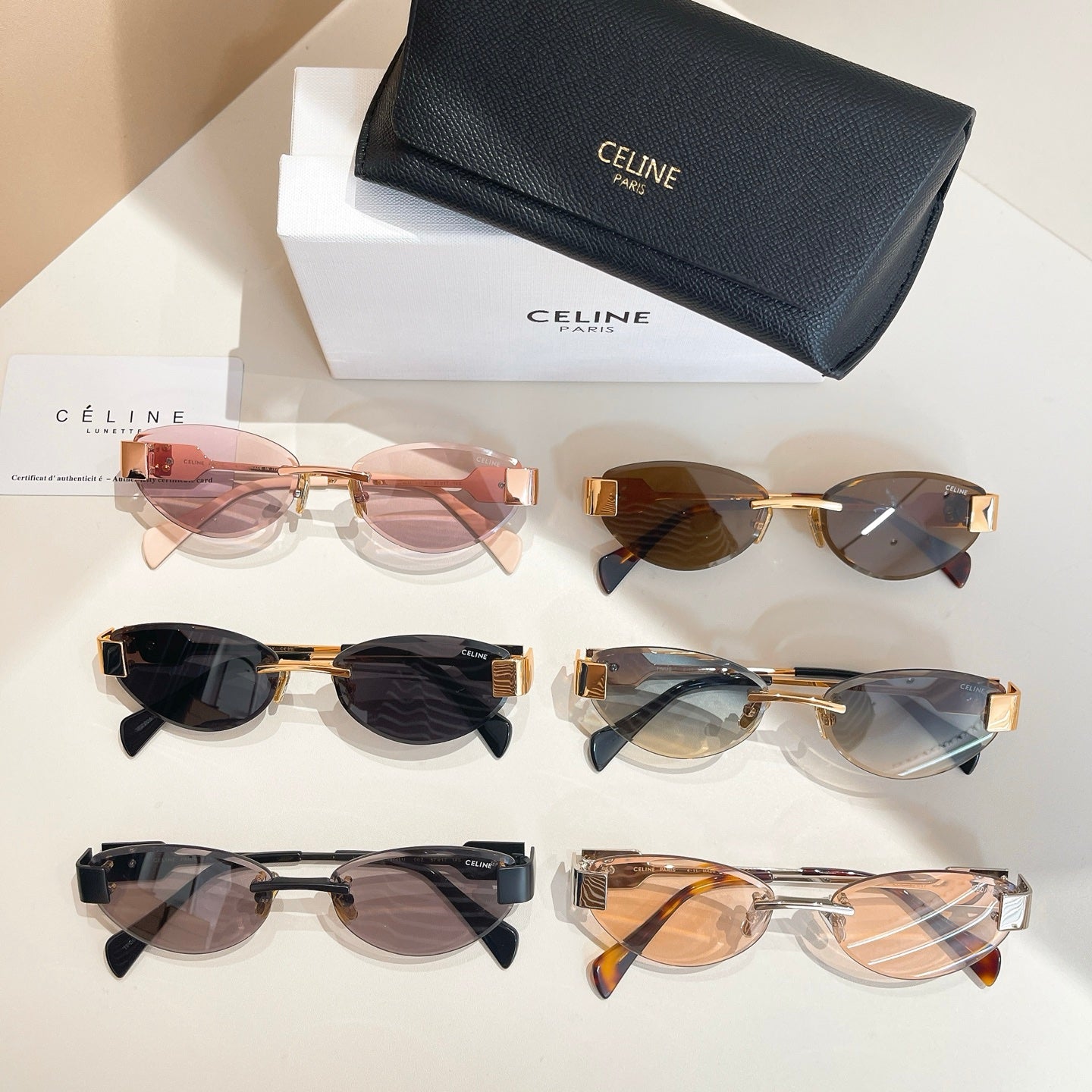 Assorted sunglasses with tinted lenses and gold-tone frames plus black case